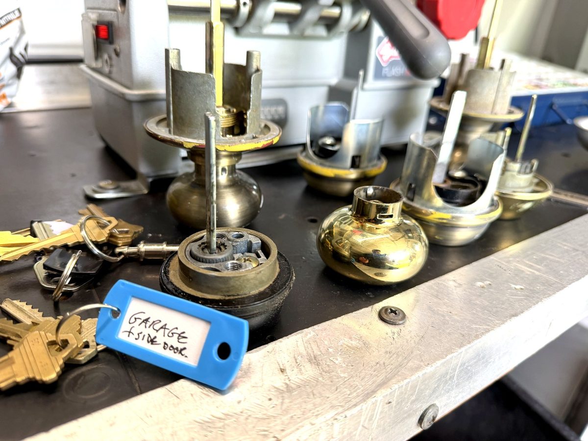 Cylinders lined up on the bench mid-rekey, keys cut and tagged as they go