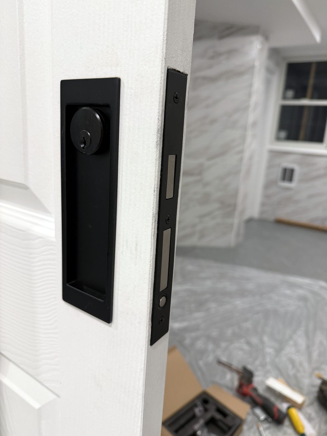 The finished pocket door from the outside — the lock sits flush so the door still slides into the wall